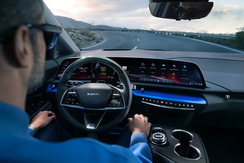 Front View of the 2026 OPTIQ-V Driving Through the Dusk Utilizing its Headlights | D'ELLA Cadillac in QUEENSBURY NY